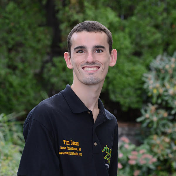 I am Caucasian male with brown hair. I am wearing a black polo with my name on the right and the logo of my business (Studio461) on the left.